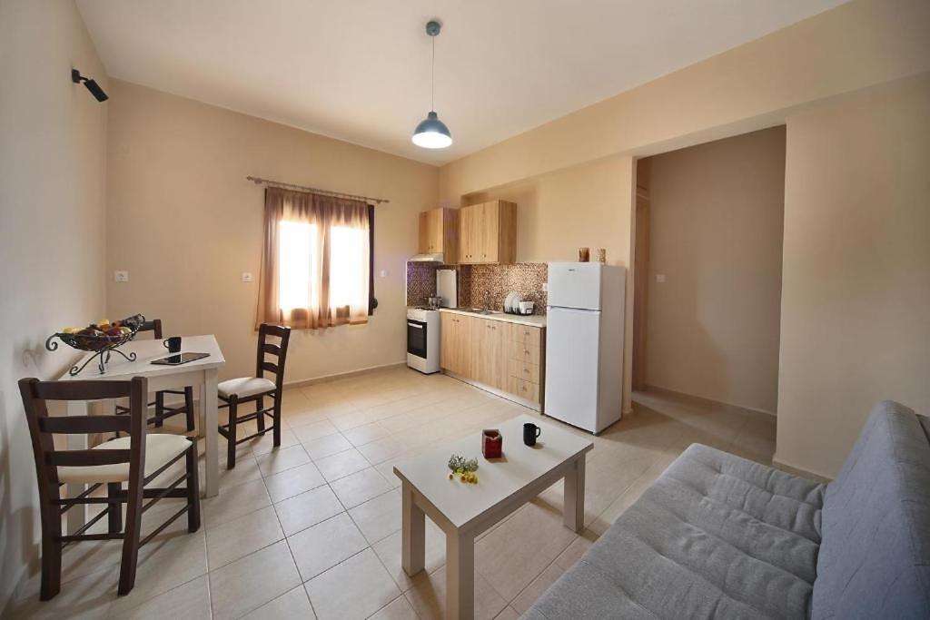a living room with a couch and a table and a kitchen at Sfakia Thea Apartments in Sfakia
