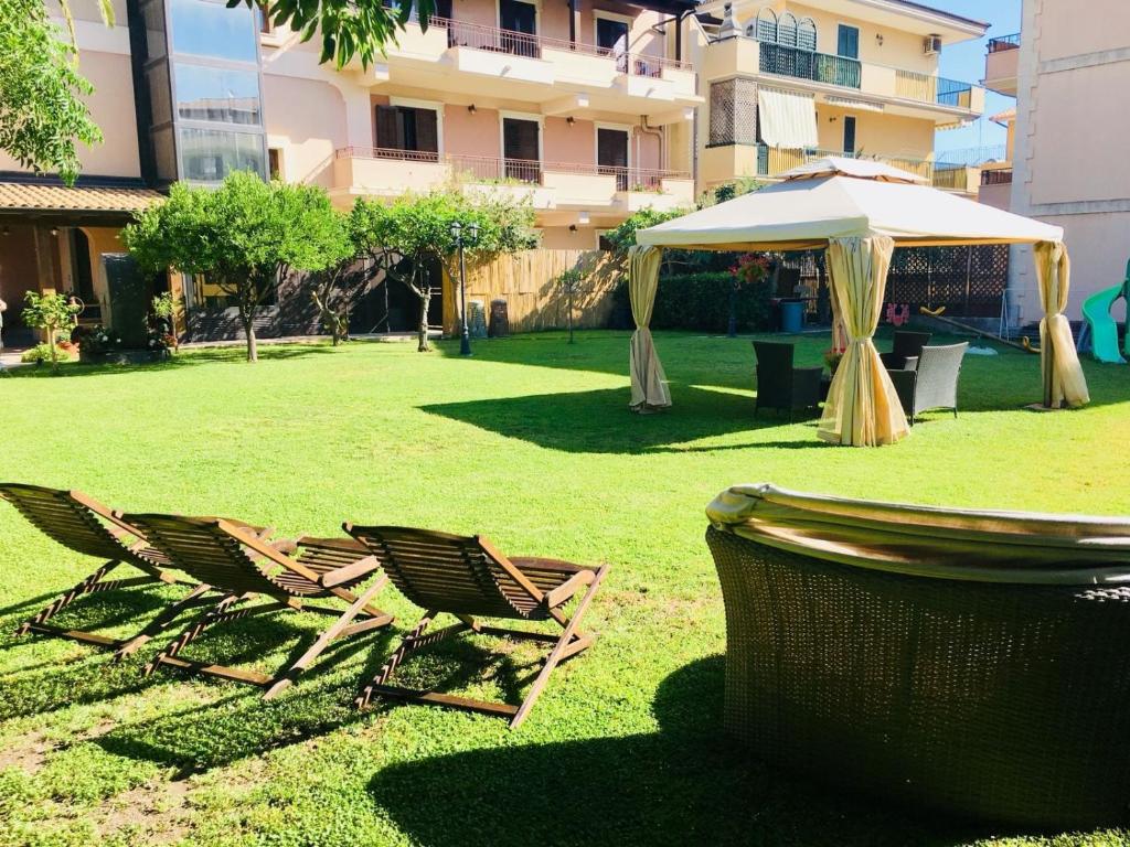 ポッツァッロにあるVilla Sea Garden - Sicily Inの草の中の椅子2脚と傘