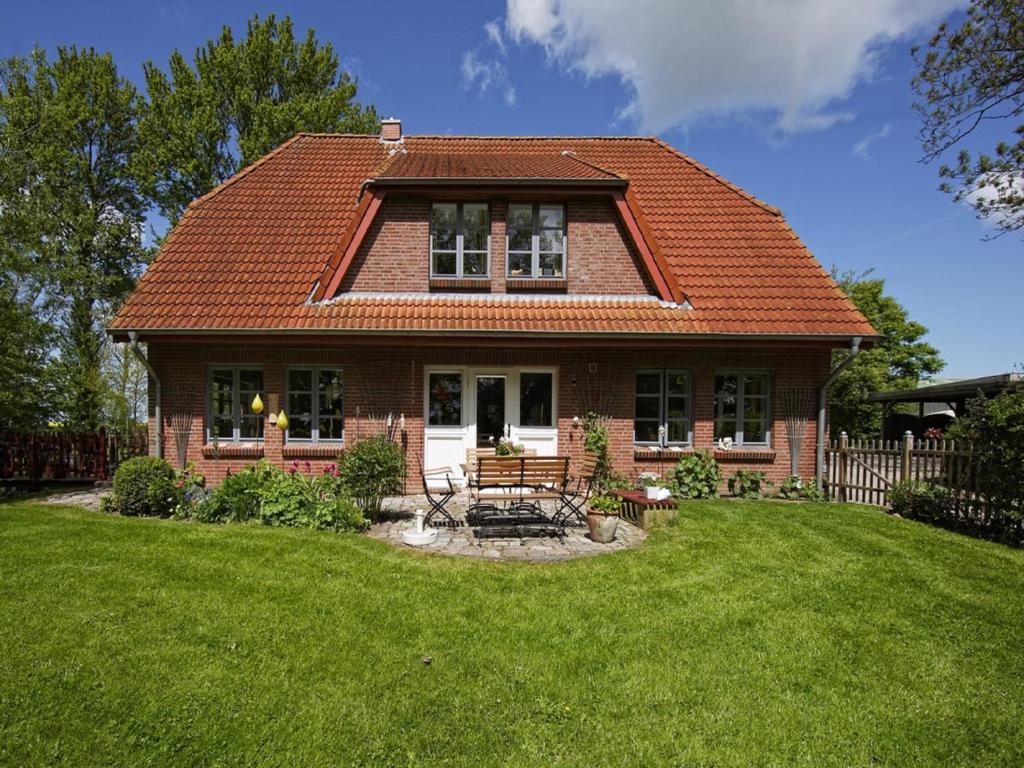 une petite maison en brique avec une pelouse dans l'établissement Ferienhof Augustenhöhe, à Fehmarn