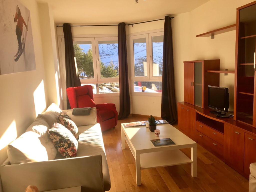 a living room with a couch and a tv at Apartamento Deluxe a Pie de Pista Miramar Ski in Sierra Nevada