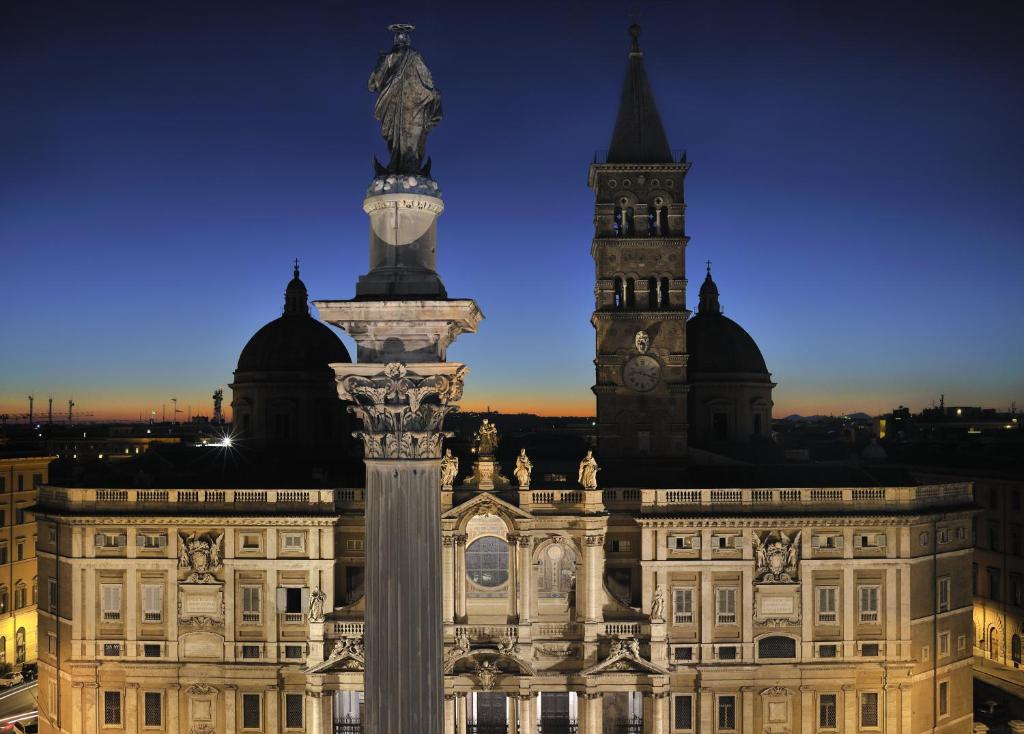 ein großes Gebäude mit einer Statue davor in der Unterkunft Hotel Mecenate Palace in Rom