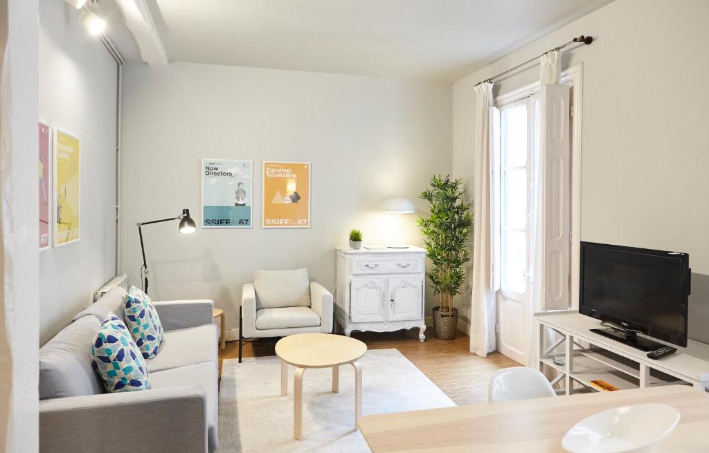 uma sala de estar branca com um sofá e uma televisão em Bergara Apartment by BasqueHomes em San Sebastián