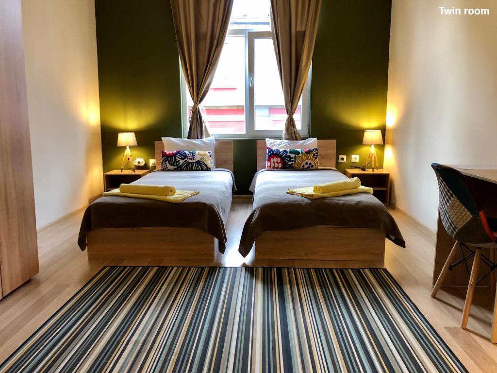 プロブディフにあるSKYLER GUEST HOUSEのベッドが2つと窓があるホテルの部屋