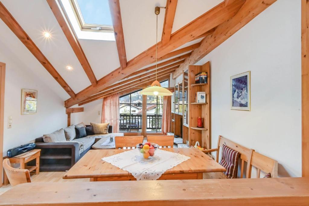 Una sala de estar con una mesa de madera y un sofá. en Katharinenhof Ferienwohnung Zugspitze (5), en Garmisch-Partenkirchen