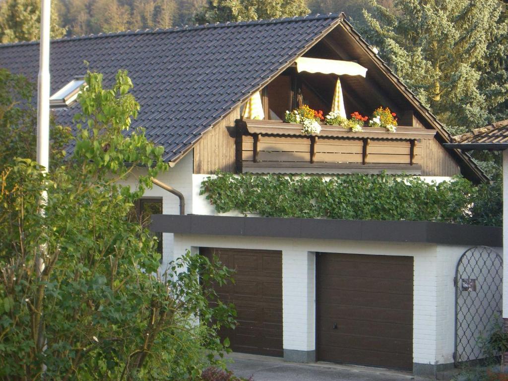 a house with a balcony with flowers on it at Ferienwohnungen Vesteblick in Dörfles