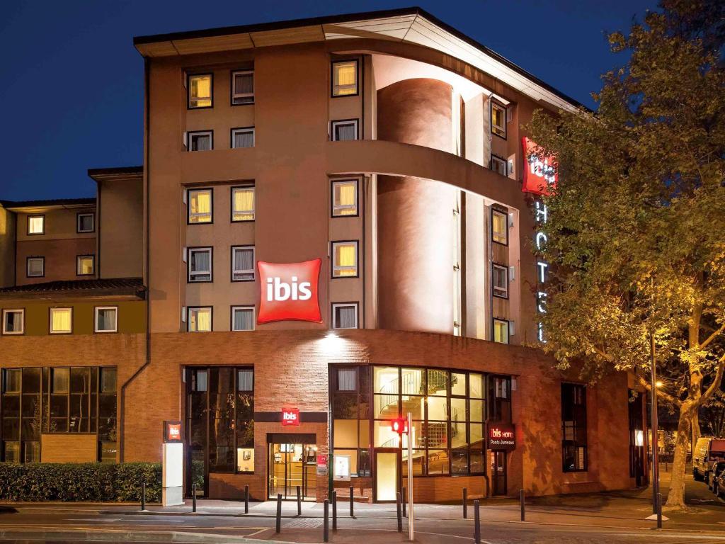 a building with a bus sign on the side of it at ibis Toulouse Pont Jumeaux in Toulouse