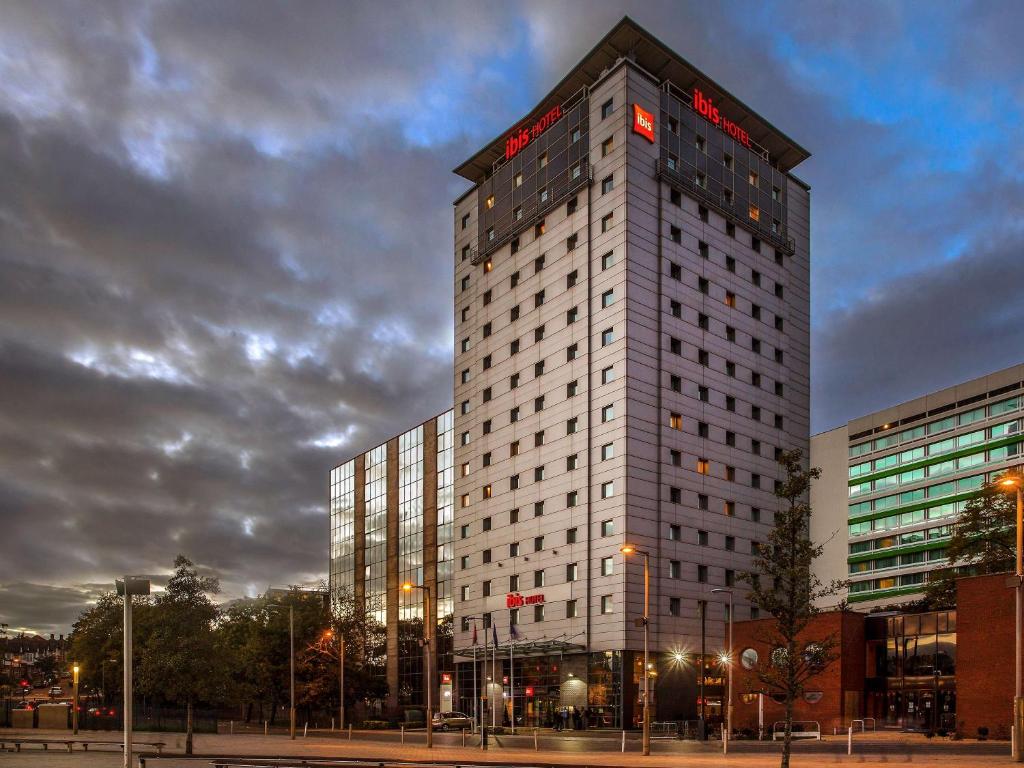 a tall building with a clock on it's side at ibis London Wembley in London