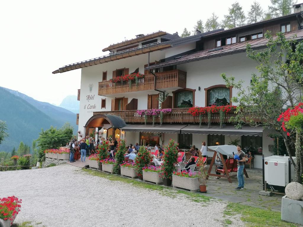 grupa ludzi siedzących przed budynkiem w obiekcie Hotel il Cardo w mieście San Vito di Cadore