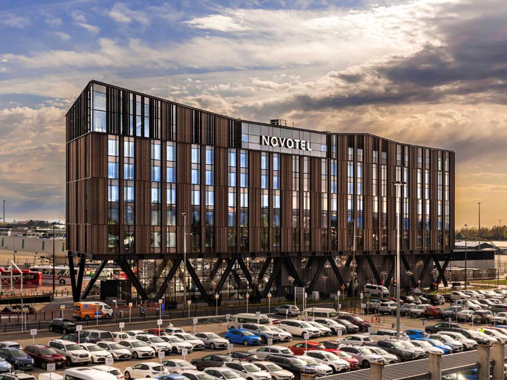 クライストチャーチにあるNovotel Christchurch Airportの駐車場の車が多い建物