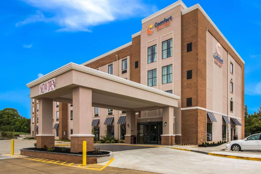 a hotel building with a car parked in a parking lot at Comfort Suites in Columbia