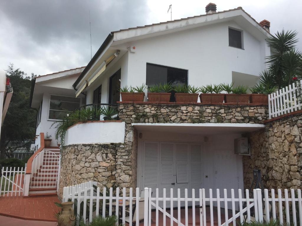 Uma casa branca com uma cerca branca à frente. em B&B Claro de luna em Tovo San Giacomo