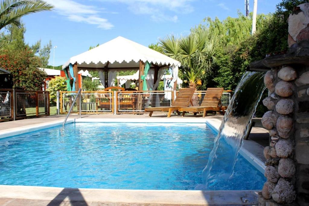 a swimming pool with a water fountain at Cabañas El Naranjo in San Rafael