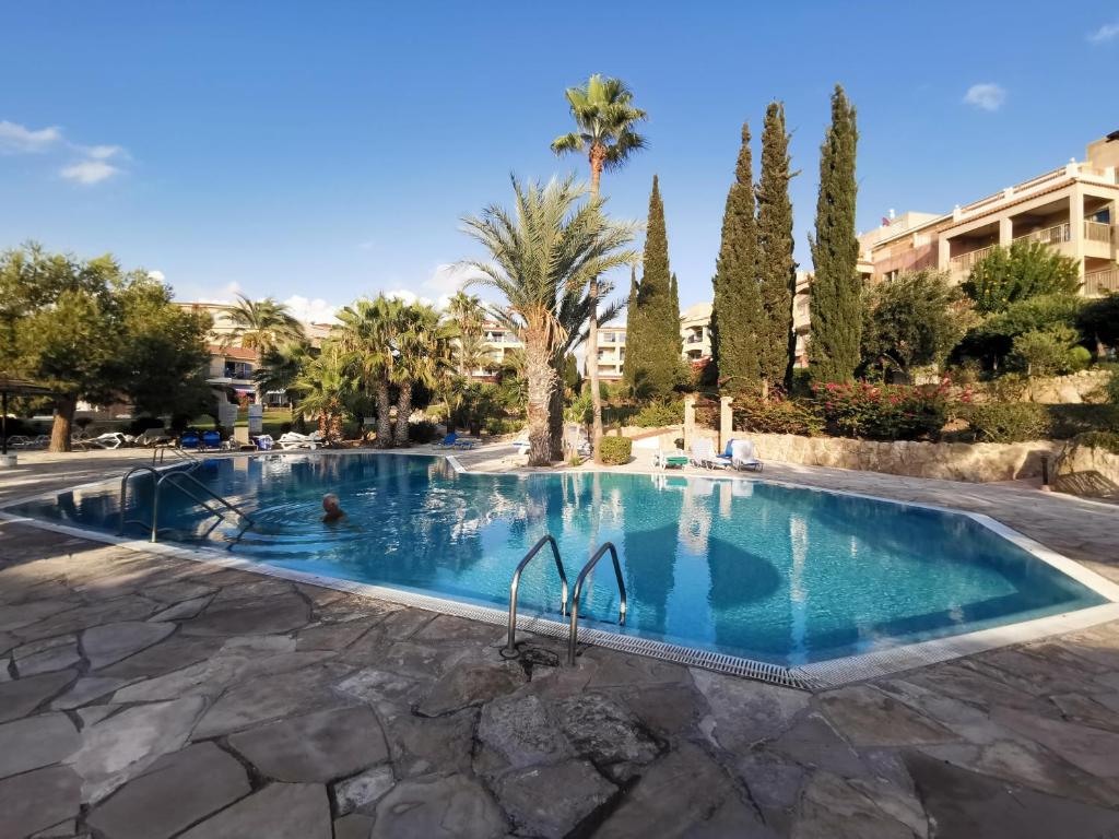 una piscina in un resort con palme di 103 Regina Gardens a Paphos