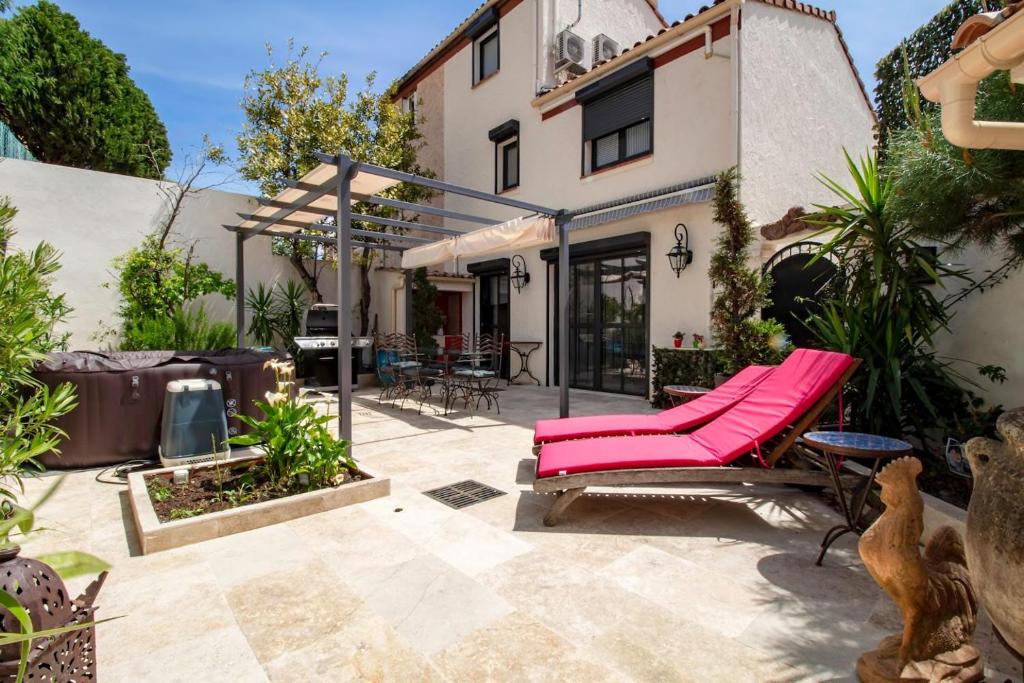 un patio con una sedia rosa e una casa di Le clos des Anges a Cogolin