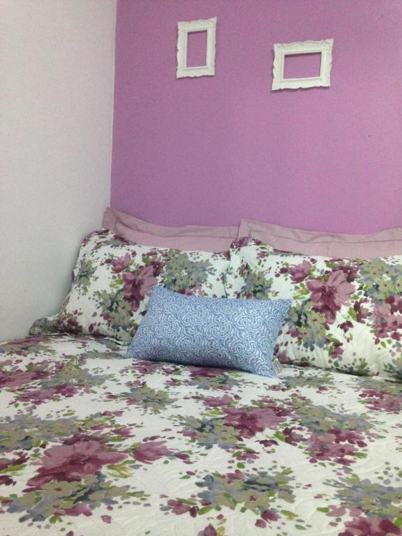 a bedroom with a bed with a purple wall at Charmoso apto com clima de casa em Canasvieiras in Florianópolis