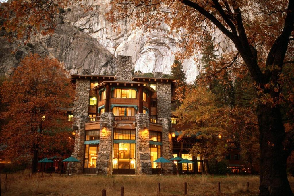 un edificio con luces encendidas frente a una montaña en The Ahwahnee en Yosemite Village