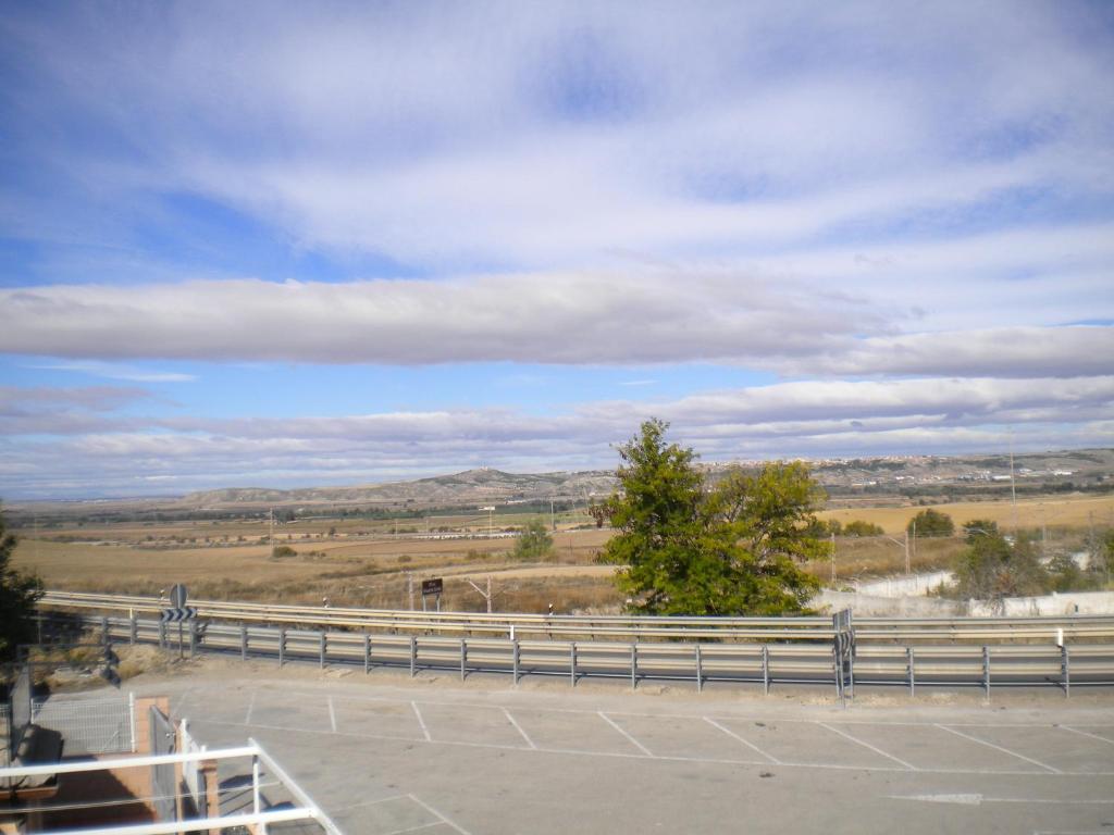 a view of a road with a fence and a field at Hostal El Rincón - Casa Marcos in Yepes
