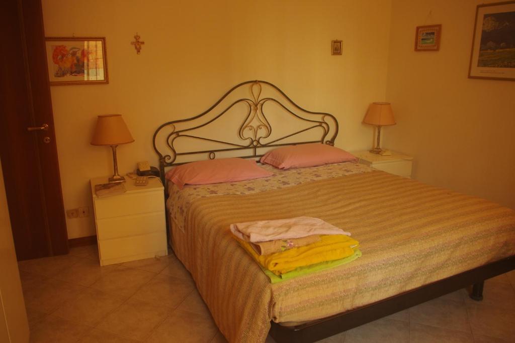 um quarto com uma cama com 2 candeeiros e 2 toalhas em casa roberta e gilberto em Bolonha