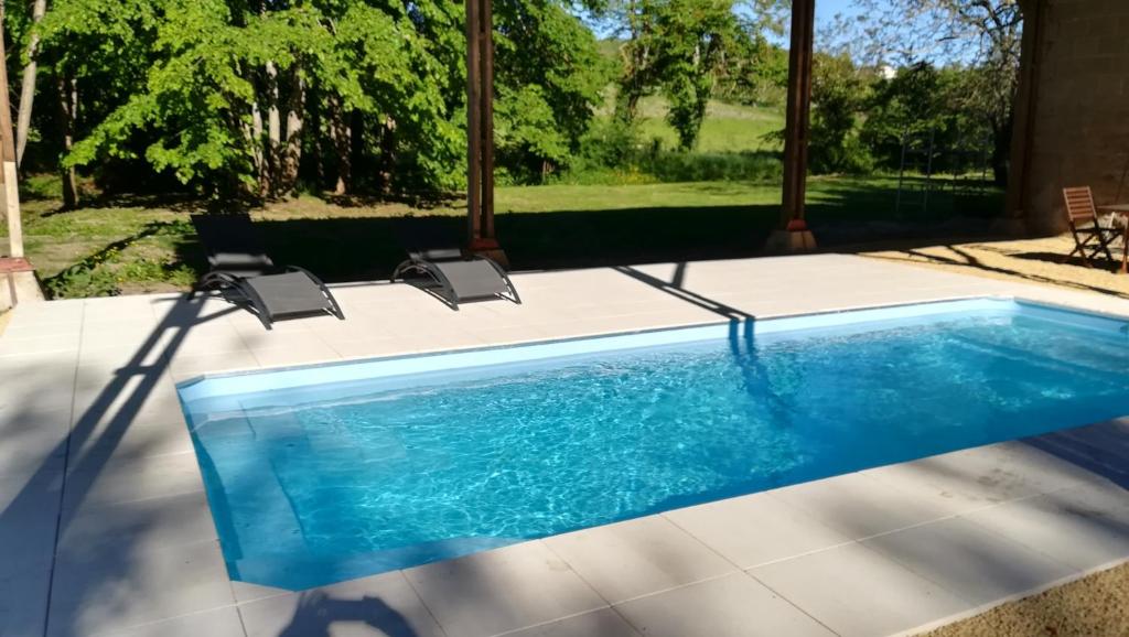 una piscina con 2 sillas en un patio en LePireau fr Gîte Ecurie Futuroscope Piscine chauffée, en Vouneuil-sur-Vienne