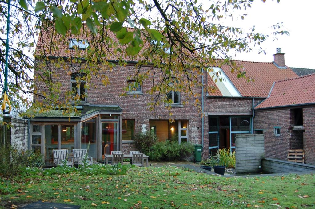 a brick house with chairs in the yard at Vakantiehuis Lazy house in Geraardsbergen