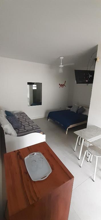 a room with two beds and a table in it at Suites Nativa in Ubatuba