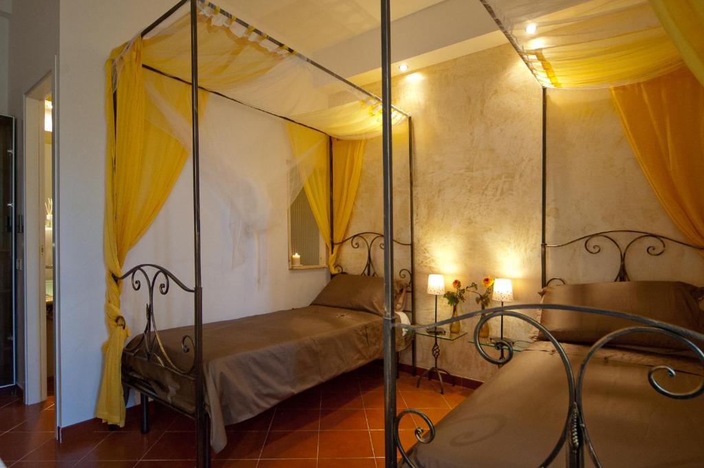 a bedroom with a four poster bed with yellow curtains at Light of Rome in Rome