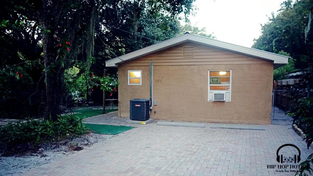 a small brown building with a brick driveway at The hip hop hotels in Tampa