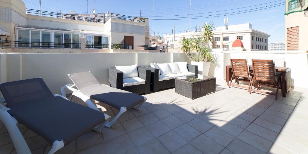 eine Terrasse mit Stühlen und Möbeln auf einem Balkon in der Unterkunft Ático Valencia Centro in Valencia