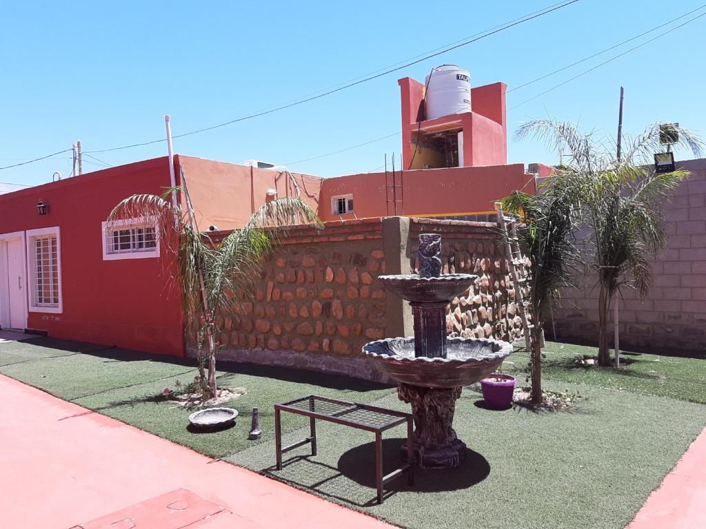 a fountain in a yard in front of a red building at Apart Hotel Del Sol in Chilecito