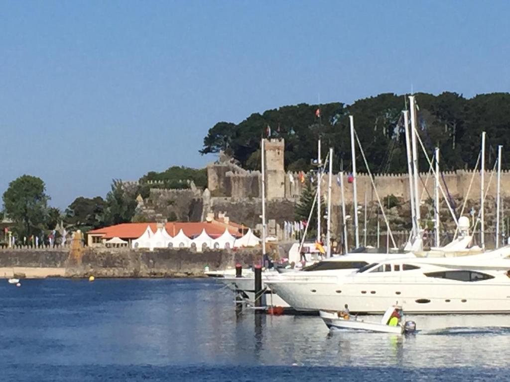 a boat docked in a marina with a castle in the background at Alojamiento Singular en Baiona in Baiona