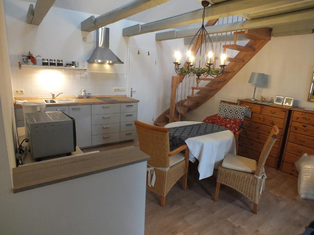 - une cuisine et une salle à manger avec une table et des chaises dans l'établissement Maisonette "im Alten Pfarrhaus", à Neuruppin