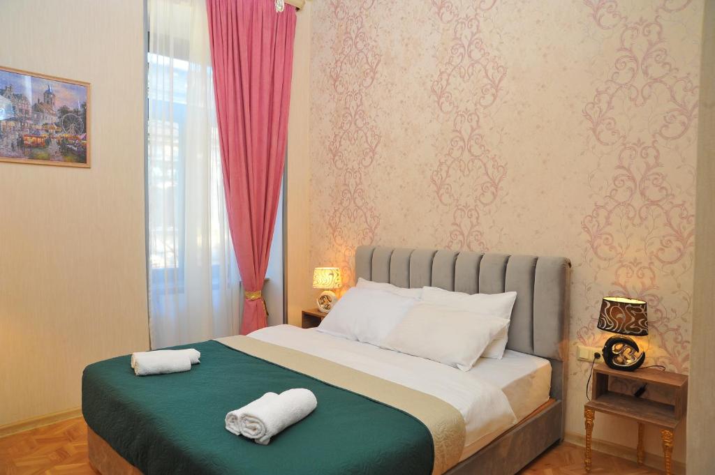 a bedroom with a bed with two towels on it at Brickwall Tbilisi-Tbilisi vibe in Tbilisi City