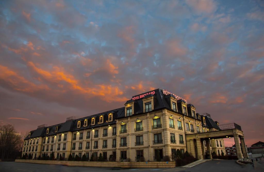 a large building with a sunset in the background at Hotel Brossard in Brossard
