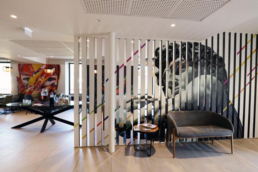 a room with a wall with a painting of a man at Hôtel la Capelle Millau in Millau