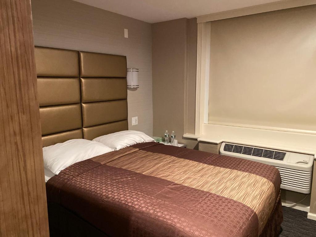 a bedroom with a bed and a dresser at Hotel Key in Queens