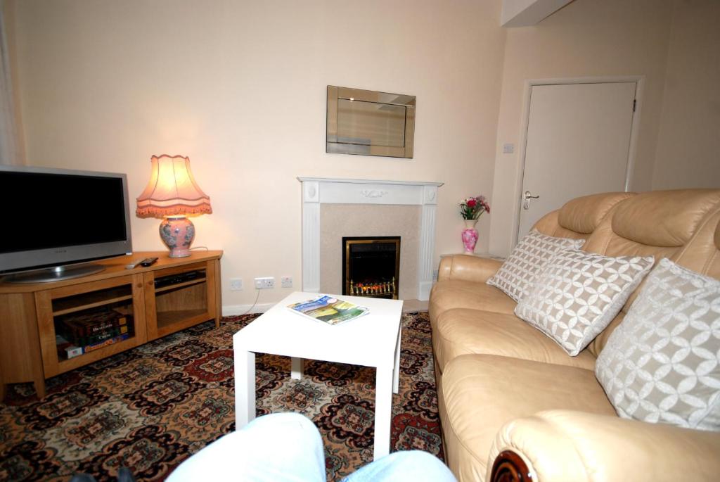 a living room with a couch and a tv at Saltburn Holidays 1 Park View Loftus in Loftus