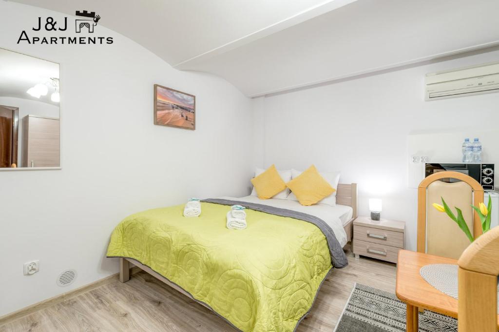 1 dormitorio con 1 cama con manta amarilla en J&J Apartments, Łazienna 30 Apartament 8/2, en Toruń