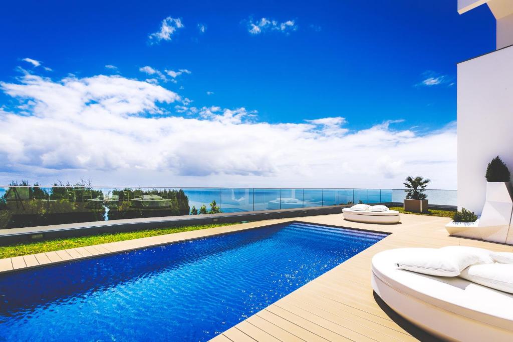a swimming pool with a view of the ocean at Luxury villa Carlota with private pool by HR Madeira in Caniço