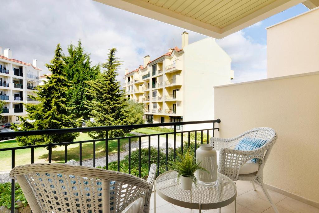 - un balcon avec deux chaises et une table avec vue dans l'établissement Gorgeous Beach Apartment - Checkinhome, à Carcavelos