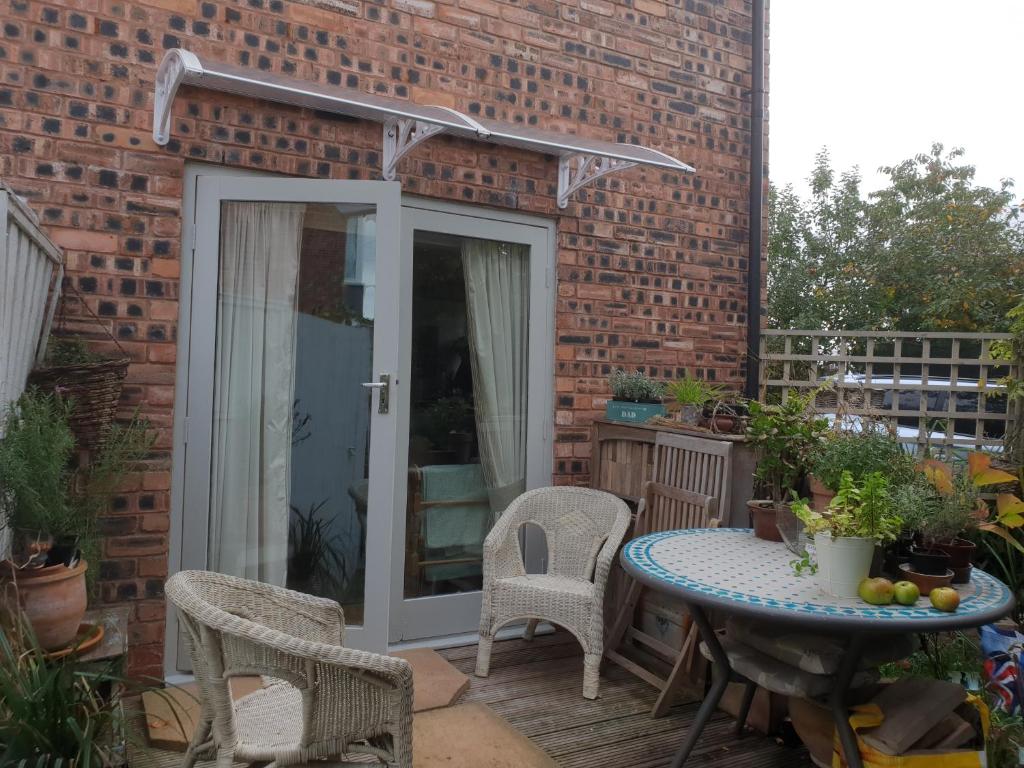 a patio with a table and chairs on a brick building at Les Chambres in Sutton