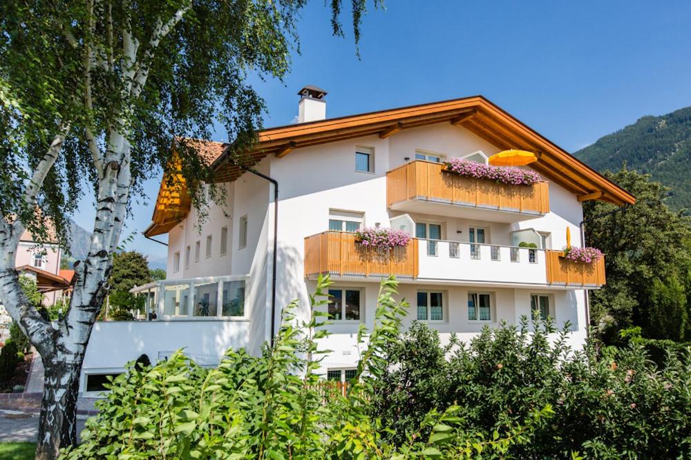 un edificio bianco con balconi e fiori di Garni Appartment Wagnerhof a Rablà