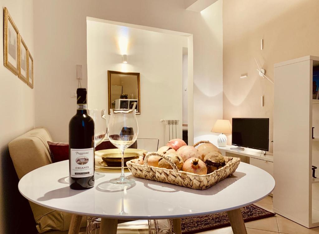 uma mesa com uma garrafa de vinho e uma cesta de pão em Casa di Vasco - Home of Vasco em San Miniato