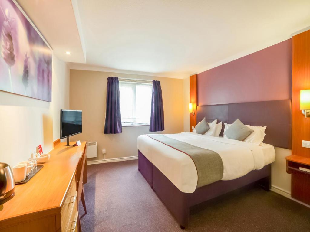 a hotel room with a large bed and a desk at OYO Lakeside Haydock Hotel, St Helens in Saint Helens
