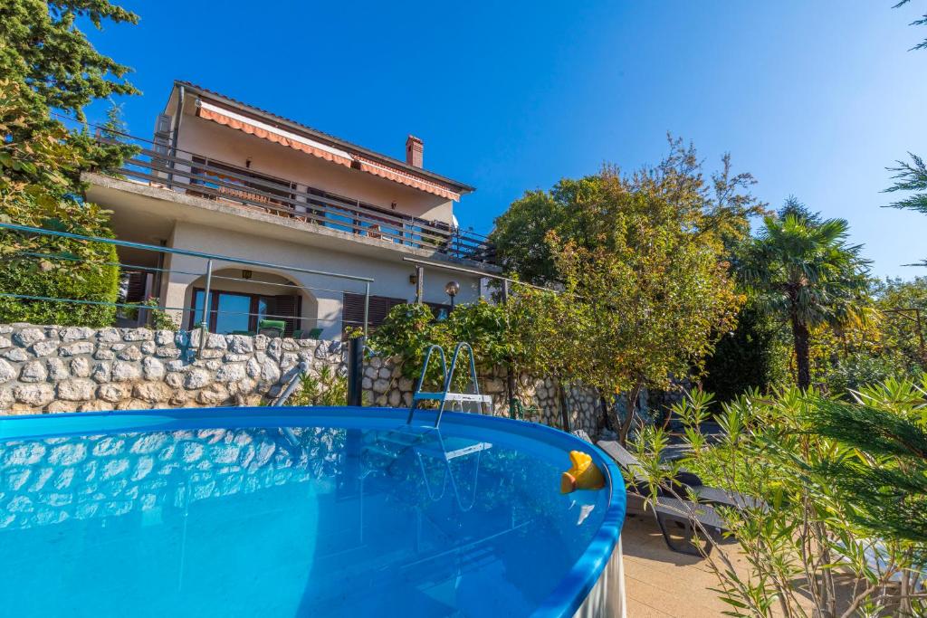 a villa with a swimming pool in front of a house at Dramalj Queen in Dramalj