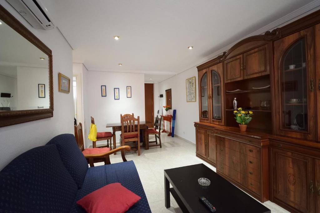 a living room with a blue couch and a table at Las Tejas - Fincas Arena in Benidorm