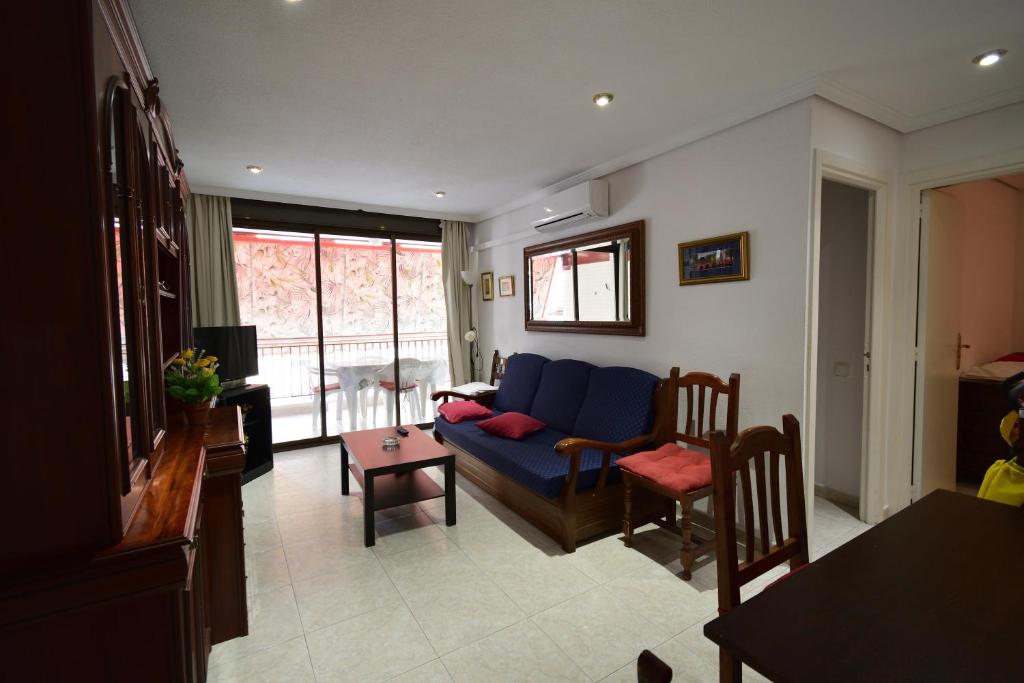 a living room with a blue couch and a table at Las Tejas - Fincas Arena in Benidorm