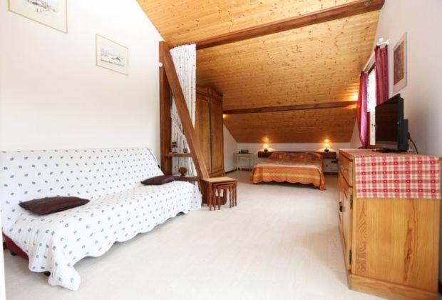 a bedroom with two beds and a television in it at Gîte de grettery in Saulxures-sur-Moselotte