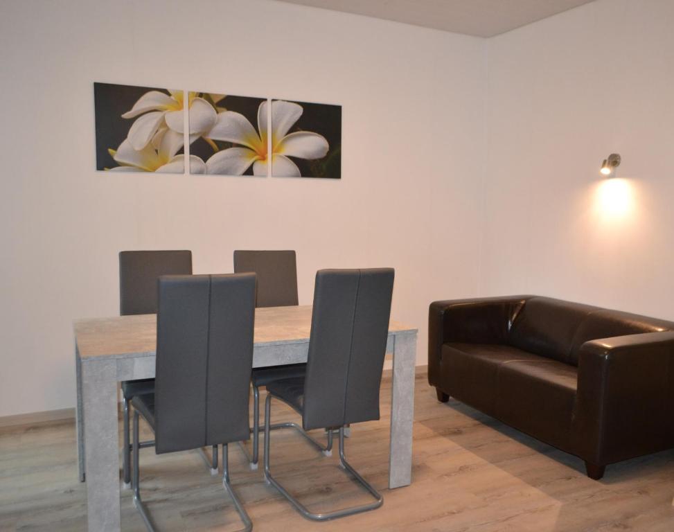 uma sala de jantar com uma mesa e cadeiras e um sofá em Ferienwohnung Krone em Sankt Johann
