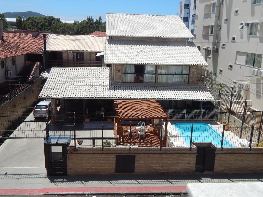 un edificio con piscina frente a un edificio en Pousada Salines, en Florianópolis