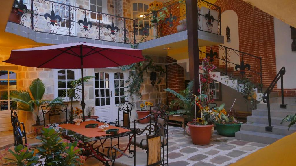 een patio met een tafel en een parasol bij Résidence Hôtelière Océane in Lomé